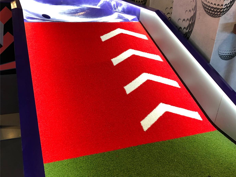 red crazy golf ramp in artificial grass